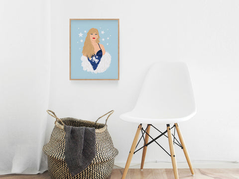 The Onderkast Studio TS Midnights Art Print, featuring a blonde woman in a blue dress with white feathers, hangs above a woven basket and modern chair, bringing contemporary charm to this minimalist space.