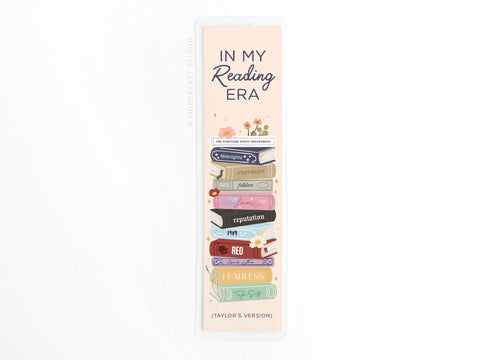 The Easyhand Goods TS In My Reading Era Laminated Bookmark features “IN MY Reading ERA” and a colorful stack of books styled as Taylor Swift album spines, showcasing vibrant print quality.
