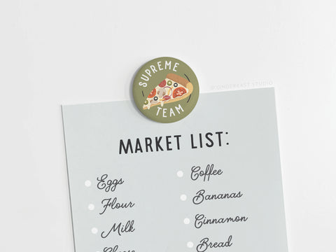 The Onderkast Studio Supreme Team Pizza Button Magnet, featuring vibrant prints and “Supreme Team” text, keeps your notes secure on any magnetic surface—making it a stylish way to display grocery lists or reminders.