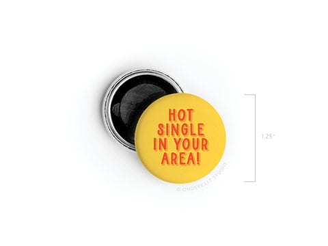 The Hot Single in Your Area! Button Magnet by Onderkast Studio is a 1.25-inch round yellow magnet with red text, shown beside its silver backing—a funny gift proudly printed in the USA.