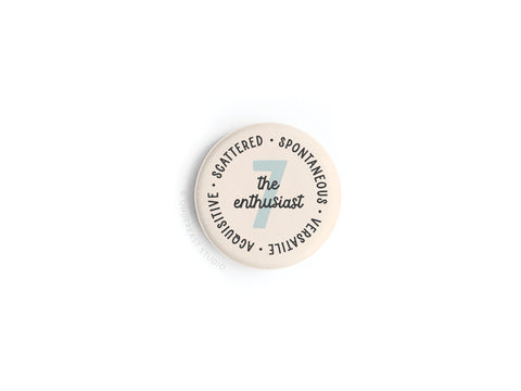 The Enneagram Button Magnet – 7 The Enthusiast by Onderkast Studio features “The Enthusiast” and traits scattered on a light background—perfect for any spontaneous, versatile, and sensitive Type 7!.