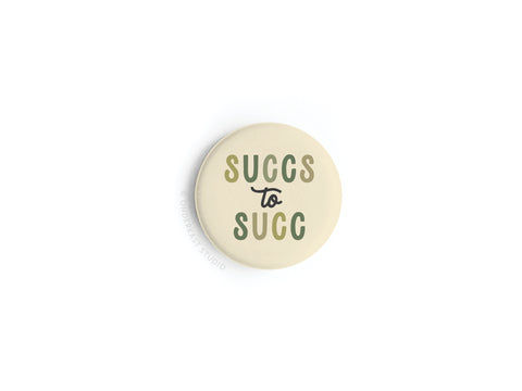 The Succs to Succ Button Magnet by Onderkast Studio is a round beige magnet with green “SUCCS to SUCC” text (with “to” in small cursive), perfect for plant parents. Shown on a white background.