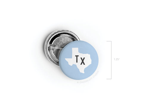 Show your state pride with the Light Blue TX Pinback Button by Onderkast Studio. This 1.25 button features a light blue background, bold black TX letters, and a white Texas outline in vibrant print.