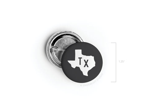 The Black TX Pinback Button by Onderkast Studio is a 1.25 round button featuring a white Texas silhouette with TX inside. Proudly printed in the USA, it’s displayed with its back on a white background—ideal for showing your state pride.