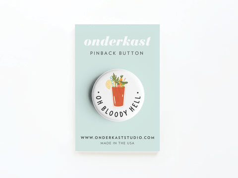 The Oh Bloody Hell Bloody Mary Pinback Button by Onderkast Studio features a quirky cocktail illustration and text, perfect for brunch lovers. Comes on a branded display card with onderkaststudio.com, made in the USA.