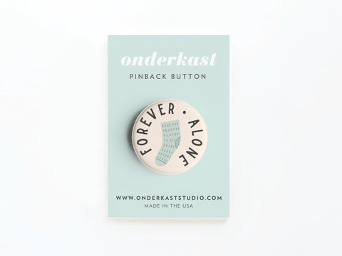 The Forever Alone Sock Pinback Button by Onderkast Studio features FOREVER ALONE circling a lone sock. Packaged on a pastel card with protective mylar, it displays ONDERKAST PINBACK BUTTON, ONDERKASTSTUDIO.COM, and MADE IN THE USA.