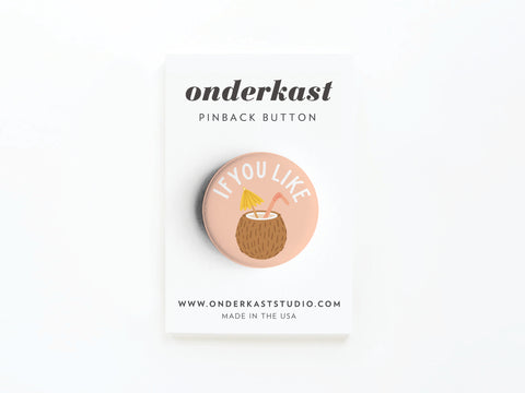 The If You Like Piña Coladas Pinback Button by Onderkast Studio features a coconut drink and straw on a peach background with “IF YOU LIKE” text. Perfect for cocktail fans, it comes attached to an Onderkast PINBACK BUTTON card.