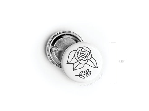 The Black Flowers Pinback Button by Onderkast Studio is a round, white 1.25-inch button with a simple black line floral design, featuring leaves and a small blossom. Printed in the USA.