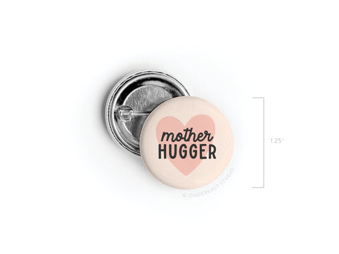 Celebrate Mothers Day with the Onderkast Studio Mother Hugger Pinback Button! This 1.25 accessory features a pale pink background, a bold black “Mother Hugger” message, and a darker pink heart—perfect for moms.