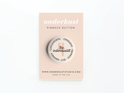 The Onderkast Studio Enneagram Pinback Button – 4 The Individualist is a round button on a beige card, featuring traits like Temperamental, Expressive, Dramatic, and Self-Absorbed.