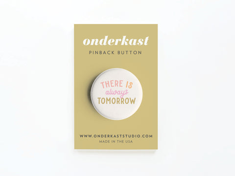 A beige card from Onderkast Studio displays the There is Always Tomorrow Pinback Button with red, yellow, and gold text—a cheerful reminder of optimism—plus the website onderkaststudio.com.