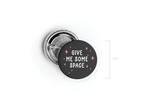 The Give Me Some Space Pinback Button by Onderkast Studio is a round, black 1.25-inch button with white text and small pink stars, highlighting the need for personal space.
