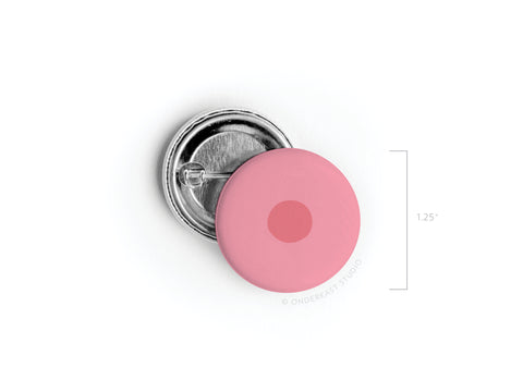 The Nipple Pinback Button – DISCONTINUED by Onderkast Studio features a vibrant pink design with a darker pink center, and measures 1.25 inches in diameter.
