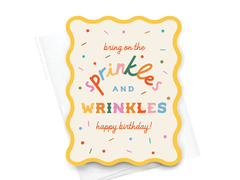 Onderkast Studios Sprinkles and Wrinkles Wavy Die Cut Notecard features colorful sprinkles, playful “bring on the sprinkles AND WRINKLES happy birthday!” text, and comes with a white envelope—perfect for birthday celebrations.