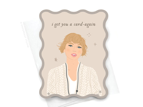 The TS Folklore Wavy Die Cut Notecard by Onderkast Studio features a woman with short blonde hair in a cream knit cardigan and the text i got you a card-again, displayed on a wavy die cut card atop a white envelope.