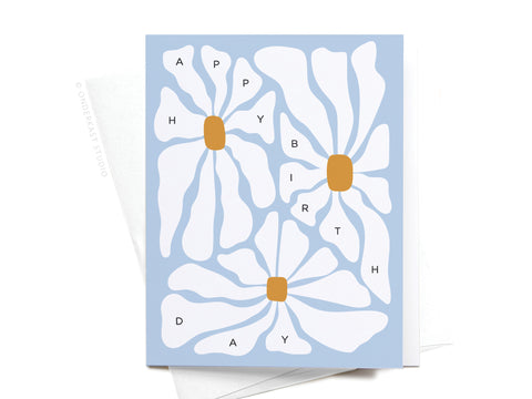 The Happy Birthday Groovy Flowers Greeting Card by Onderkast Studio features three large, abstract white blooms on a light blue background. Each petal displays a letter to spell out HAPPY BIRTHDAY, creating a fun, retro birthday vibe.