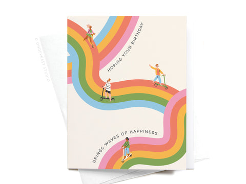 The Onderkast Studio Waves of Happiness Birthday Greeting Card features people biking and scootering on rainbow paths—its vibrant colors and premium feel make it perfect for sending joyful wishes on any special day.