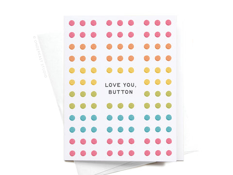 The Love You Button Candy Greeting Card – FINAL STOCK by Onderkast Studio features playful pink, orange, yellow, green, and blue dots in a grid with LOVE YOU, BUTTON at the center—evoking nostalgic button candy. Envelope included.