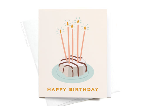 The Happy Birthday Zebra Cake Greeting Card by Onderkast Studio features a small cake with chocolate drizzle, five lit candles, and HAPPY BIRTHDAY in yellow. A premium envelope is included behind the card.
