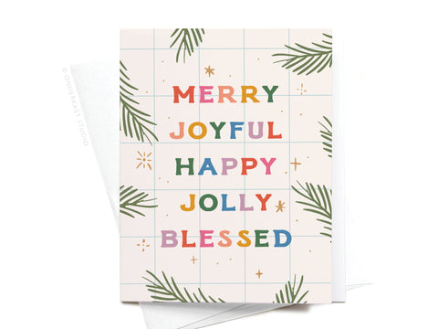 The Merry Joyful Christmas Spruce Greeting Card by Onderkast Studio features green corner leaves and colorful festive text on a white grid background, printed vibrantly with a partially visible envelope underneath.