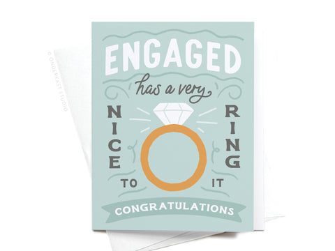 The Onderkast Studio Engaged Has a Very Nice Ring to It Greeting Card features a diamond ring design and congratulatory message in stylish fonts on a light blue background.