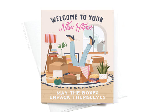 The Onderkast Studio Welcome to Your New Home Boxes Greeting Card features an illustration of someone upside down in moving boxes with a cat on the windowsill and the message: Welcome to your new home. May the boxes unpack themselves.