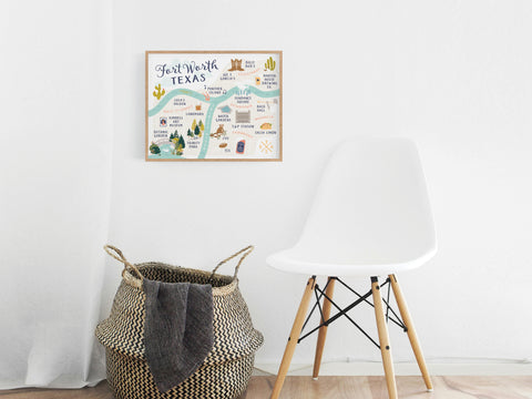A minimalist room features a white chair, a woven basket with a blanket, and a premium touch from the Onderkast Studio Fort Worth Map Art Print displayed in a frame on the white wall.