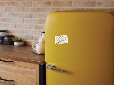 A mustard yellow retro fridge in a kitchen with wooden cabinets, jars, and a brick-style backsplash features a small illustrated note and the Onderkast Studio Fort Worth Map Refrigerator Magnet.