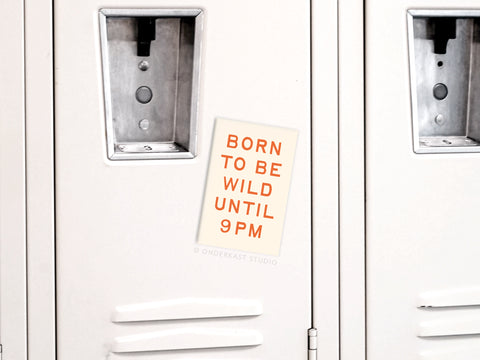 A white locker with the Onderkast Studio Born To Be Wild refrigerator magnet in bold orange stands out, playful among adjacent lockers, echoing its message: Born To Be Wild UNTIL 9PM.