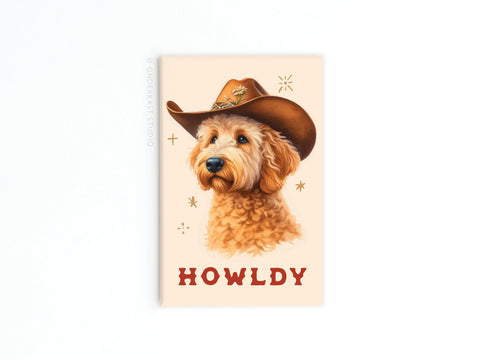 The Howldy Cowboy Dog Refrigerator Magnet by Onderkast Studio features a fluffy golden doodle in a cowboy hat with HOWLDY in red letters, star accents, and a light beige background—perfect for adding Western charm to your space.