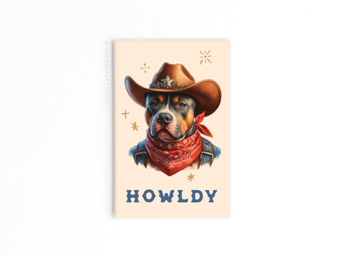 The Howldy Cowboy Dog Refrigerator Magnet from Onderkast Studio shows a playful pup in a cowboy hat and red bandana with “HOWLDY” below, adding western charm to your fridge.