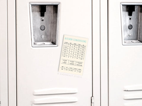 A white locker displays the Onderkast Studio Kitchen Conversions Refrigerator Magnet on its door, showing common measurement equivalents—ideal for quick cooking reference.