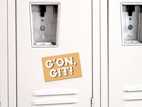 A beige locker features a tan sign with GON, GIT! in bold white playful letters, echoing the rustic charm of Onderkast Studios G’on Git Refrigerator Magnet.