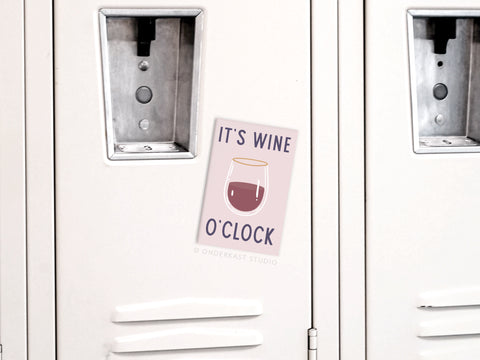 A light-colored locker features the Onderkast Studio It’s Wine O’clock Refrigerator Magnet, which displays a wine glass and the playful phrase, adding a fun kitchen decor touch to the door.