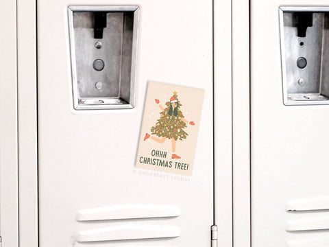 The Ohh Christmas Tree Girl Refrigerator Magnet by Onderkast Studio features a girl dressed as a Christmas tree, playful hand-drawn decorations, and vibrant colors—perfect for adding festive cheer to your fridge.