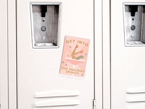 Add a touch of cheer with Onderkast Studio’s “Into the Holiday Spirits Martini Girl Refrigerator Magnet”—featuring a chic martini glass and festive message, it’s perfect for decorating your fridge or locker this season.