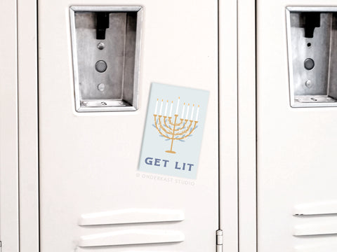 A white locker displays the Onderkast Studio Get Lit Menorah Refrigerator Magnet, which features a festive menorah and “GET LIT” in blue letters on its door.