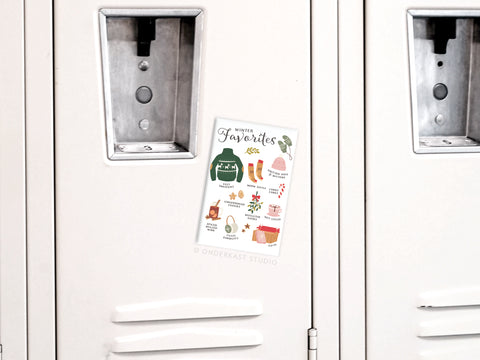 A white locker displays the Onderkast Studio Winter Favorites Refrigerator Magnet, adorned with cozy items—socks, tea, sweater, books, and mittens—ideal for festive holiday decor or adding cheer to your fridge.