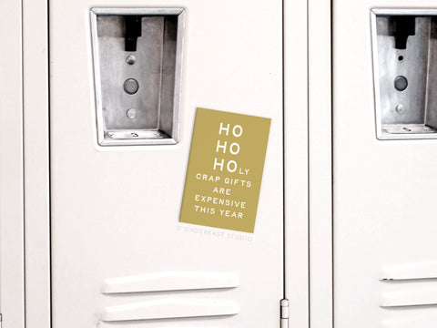 The Ho Ho Holy Crap Gifts Are Expensive Refrigerator Magnet by Onderkast Studio adds holiday humor to your decor with its beige design and bold white-and-gold text—a fun reminder of pricey gifts this season.