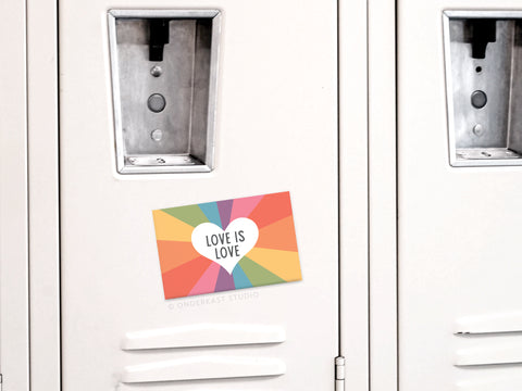 The Onderkast Studio Love Is Love Refrigerator Magnet features a colorful rainbow and heart with LOVE IS LOVE, celebrating equality and inclusion on any light gray locker door.