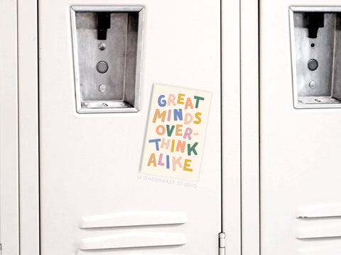A vibrant Onderkast Studio Great Minds Overthink Alike Refrigerator Magnet is displayed on a beige locker with vents and locks. Made in the USA.