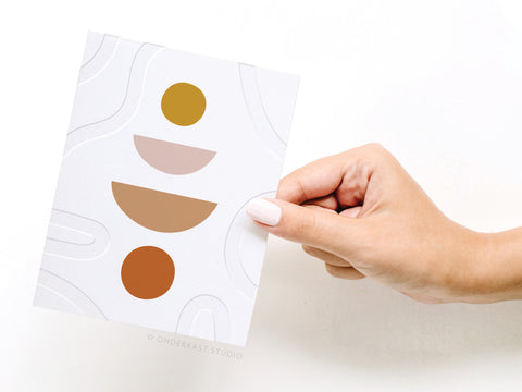 a hand holding a piece of paper with a design on it