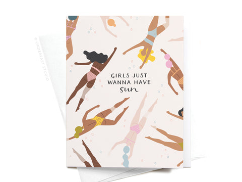 The Girls Just Wanna Have Sun Greeting Card – FINAL STOCK by Onderkast Studio features diverse women in swimsuits swimming among bubbles and vibrant colors, with “Girls Just Wanna Have Sun” at the center. Shown resting on a white envelope.