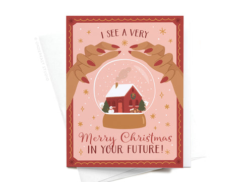 Send festive cheer with the I See a Very Merry Christmas In Your Future Greeting Card by Onderkast Studio. Features two hands with red nails holding a snow globe and cheerful holiday accents. FINAL STOCK—perfect for magical greetings!.