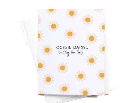 The Onderkast Studio Oopsie Daisy Belated Birthday Greeting Card features light pink and yellow daisies with OOPSIE DAISY… sorry I’m late! in black on white, plus an envelope.