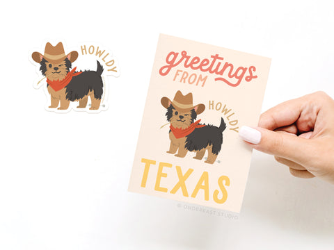 A hand holds Onderkast Studios Greetings From Texas Sticker Greeting Card, featuring a cartoon dog in a cowboy hat, red bandana, and straw, with Greetings from howdy TEXAS printed above and a matching vinyl sticker beside the card.