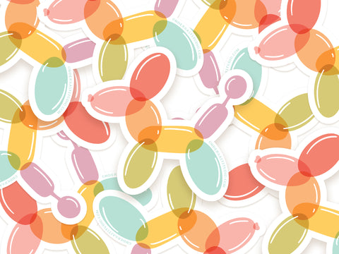 Onderkast Studio’s Balloon Animal Sticker features durable, water-resistant vinyl dog designs in pastel orange, yellow, pink, blue, and green scattered and overlapping on a white background.
