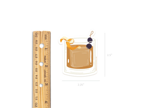 The Onderkast Studio Old Fashioned Cocktail Sticker is a durable, water-resistant vinyl sticker featuring an Old Fashioned with an orange twist and two cherries. It measures about 2.25 wide by 2.5 tall.