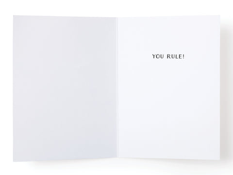 The Onderkast Studio Yass, Queen! Greeting Card – FINAL STOCK is an open premium card with blank white pages. In bold black text on the right, it says YOU RULE!—a minimalist and empowering friendship card.