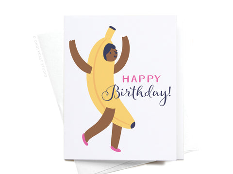 Celebrate with the Onderkast Studio Happy Birthday! Banana Suit Girl Greeting Card in a dark color, featuring a smiling girl in a banana suit and pink shoes with raised arms—perfect for any fun birthday occasion.